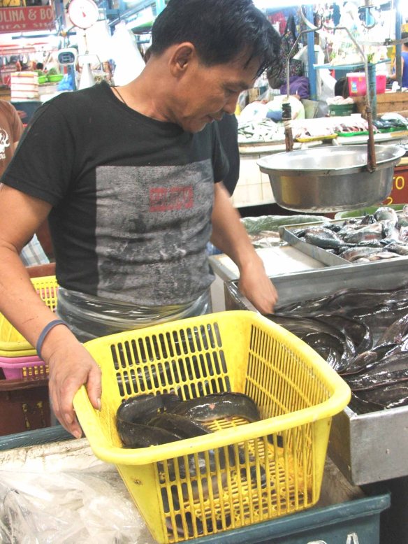 This customer gamely poses while choosing from among the live and squirming hito (snakehead), a type of mudfish. Sells for P120 a kilo.